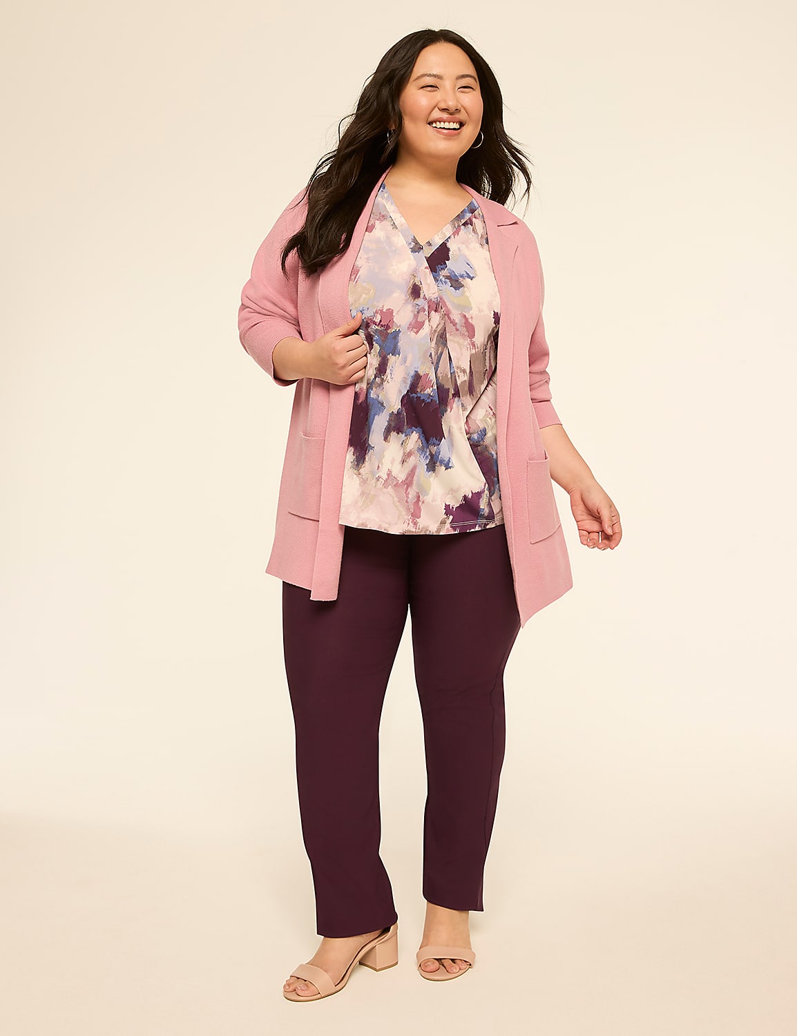 A smiling woman in a pink blazer, floral blouse, and plum pants stands against a plain, light-colored background. Product Image 4