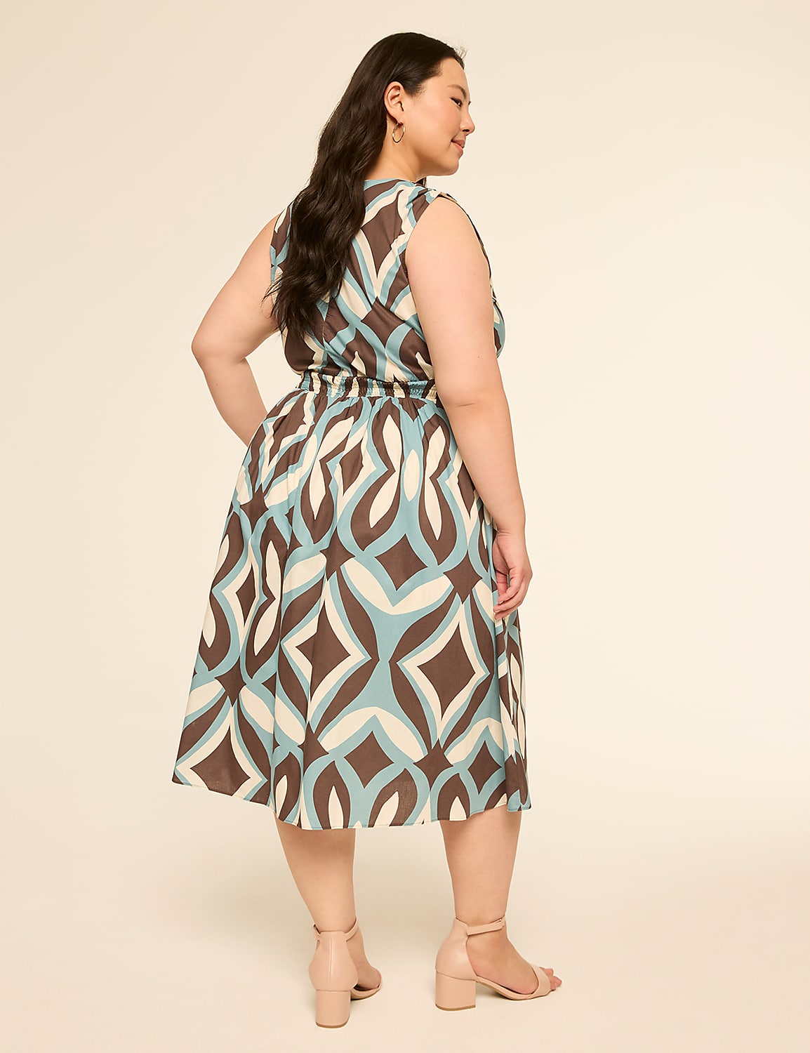 A woman in a patterned dress stands against a plain, light-colored background. Product Image 2