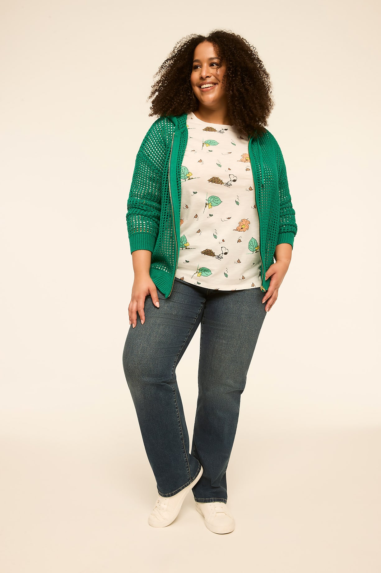 A smiling woman in a green cardigan and a t-shirt with a hedgehog print stands against a plain, light-colored background. Product Image 5