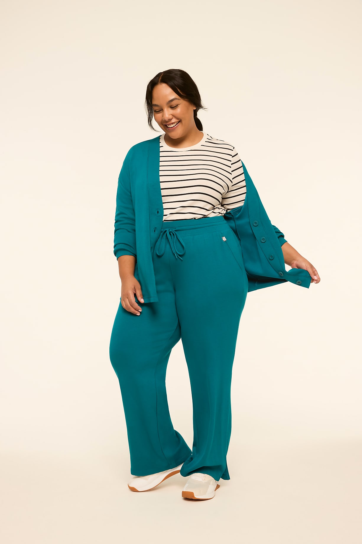 A smiling woman in a teal cardigan and matching pants stands against a plain, light-colored background. Product Image 6
