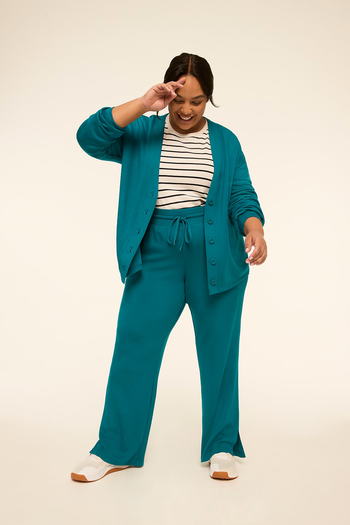 A smiling woman in a teal cardigan and matching pants stands against a plain, light-colored background. Product Image 8