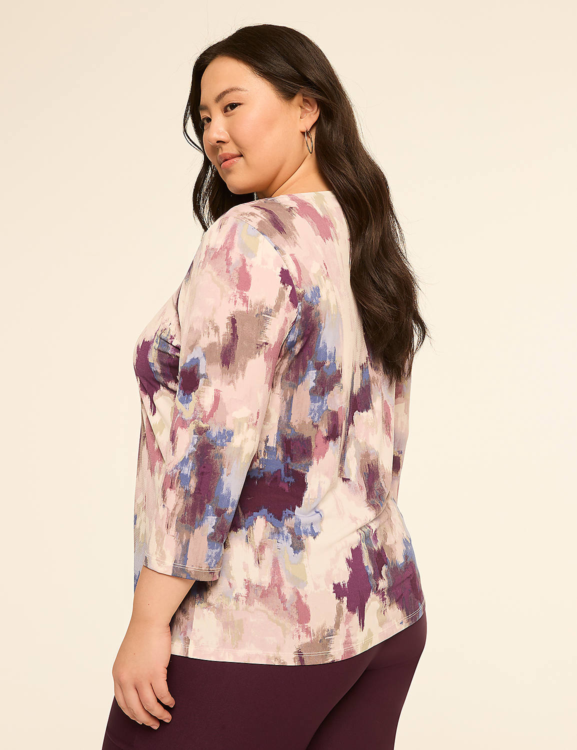 A woman in a colorful abstract print top and dark pants poses against a plain, light-colored background. Product Image 2
