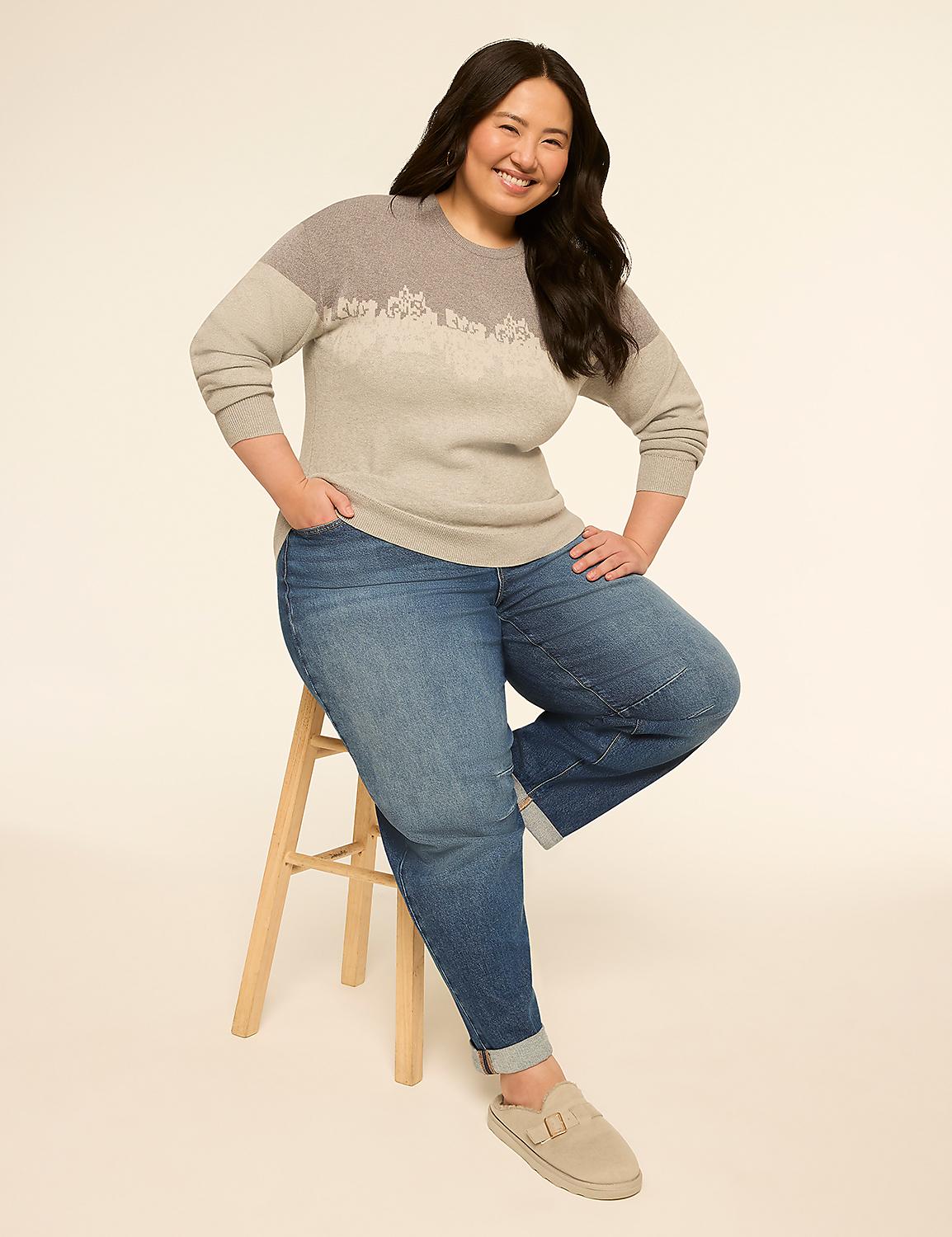 A smiling woman in a sweater and jeans sits on a stool against a plain, light background. Product Image 3