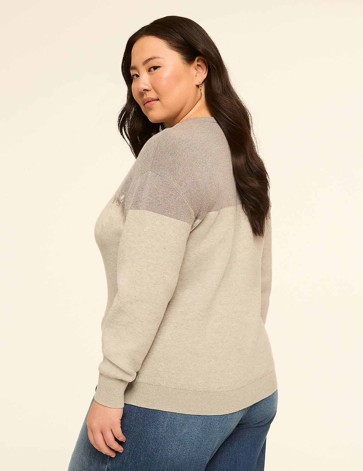 A woman in a two-toned sweater and jeans poses against a plain, light-colored background. Product Image 2