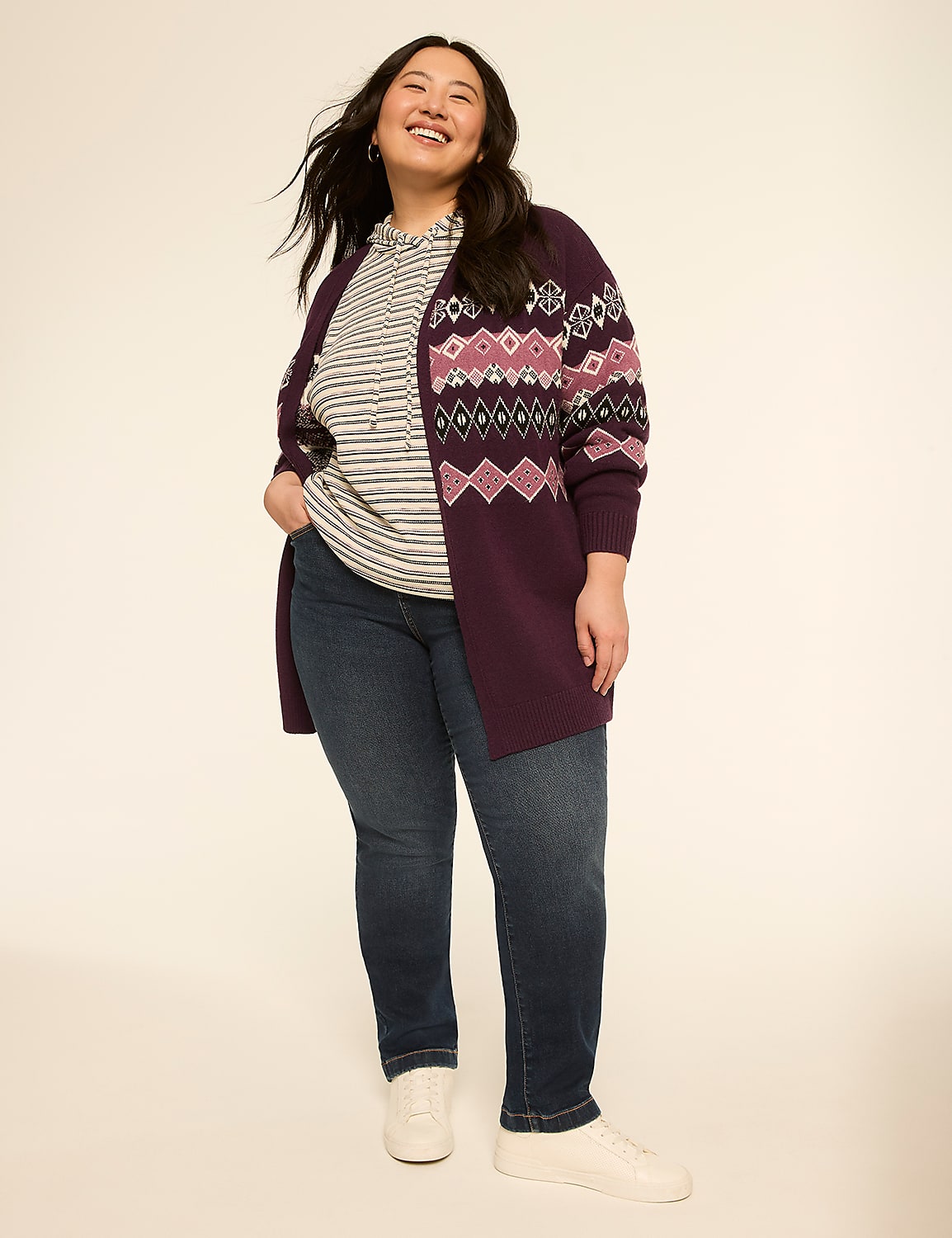 A smiling woman in a patterned cardigan and jeans stands against a plain, light background. Product Image 4