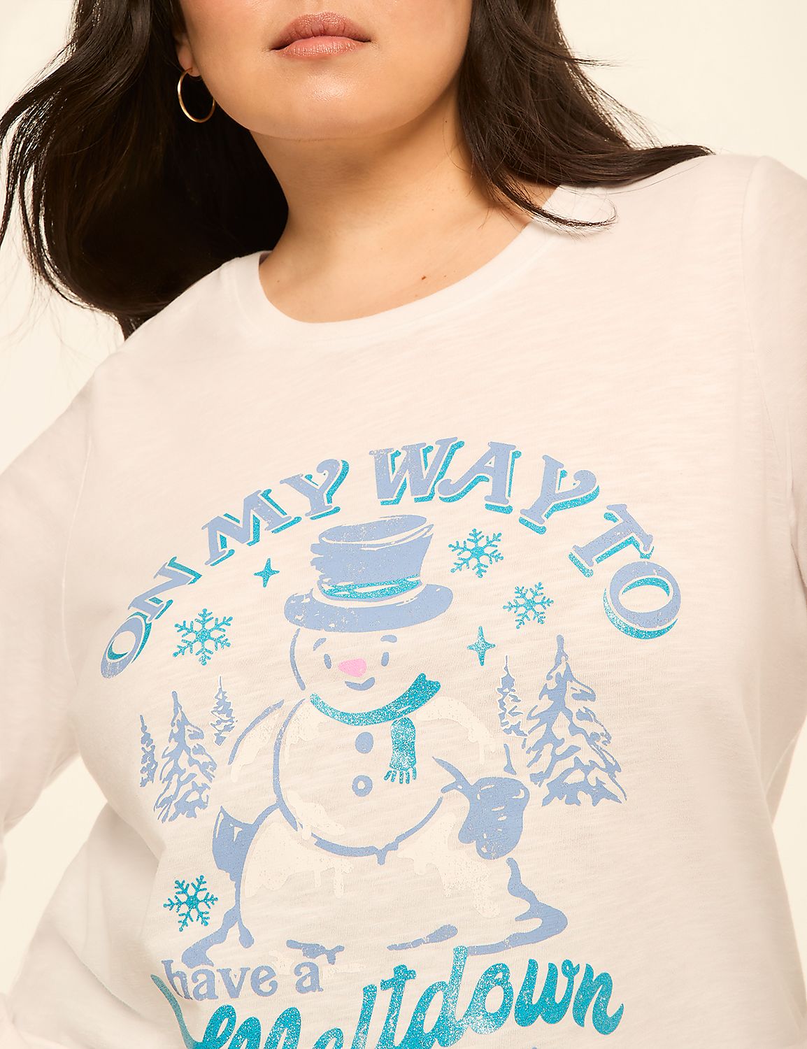 A close-up of a white long-sleeved shirt with a cheerful snowman graphic and snowflakes, set against a plain background. Product Image 4
