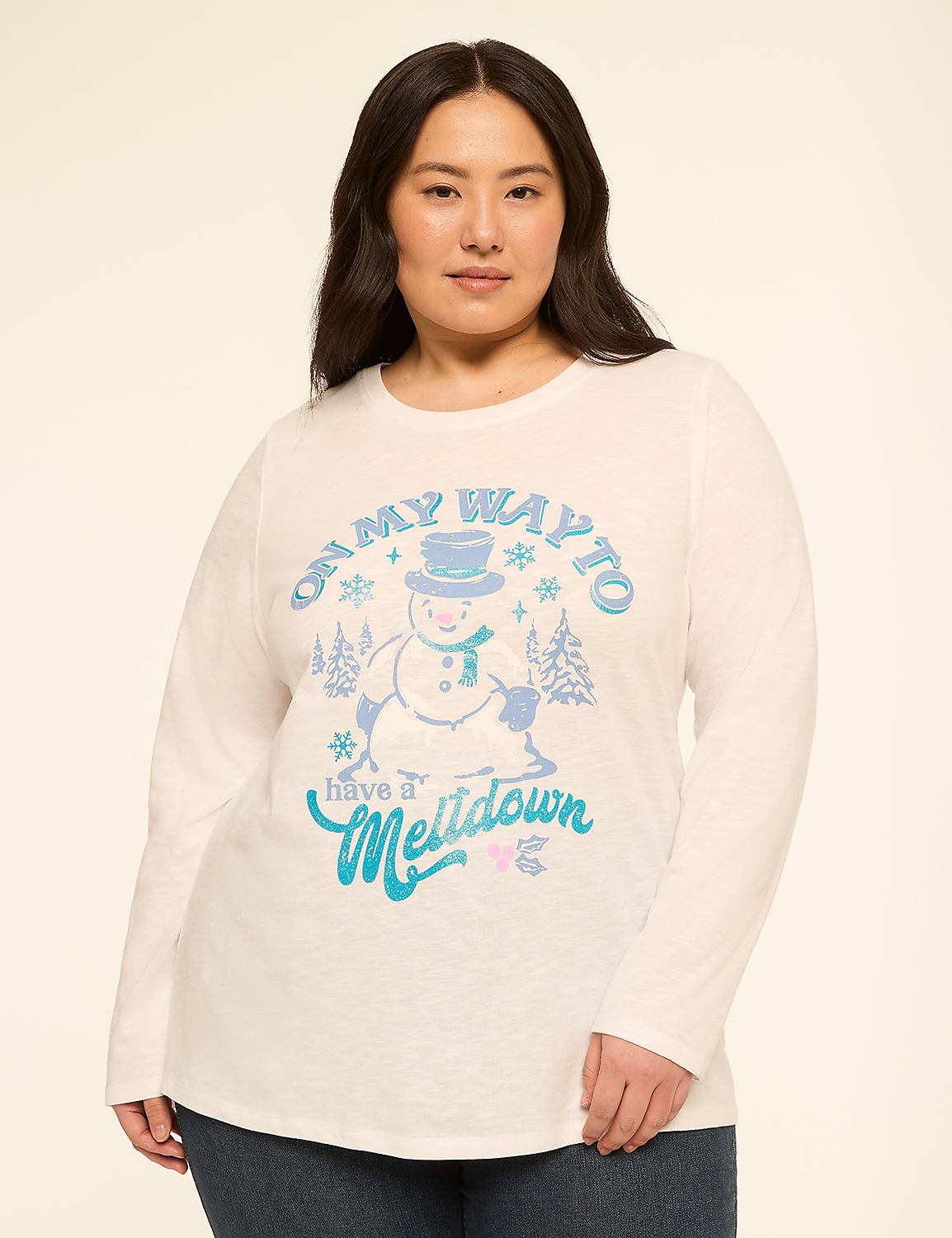 A woman in a white long-sleeved shirt with a snowman graphic stands against a plain, light-colored background. Product Image 1