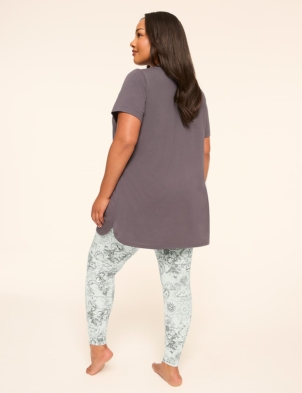 A woman in a grey tunic and patterned leggings stands with her back to the viewer against a plain, light background. Product Image 2