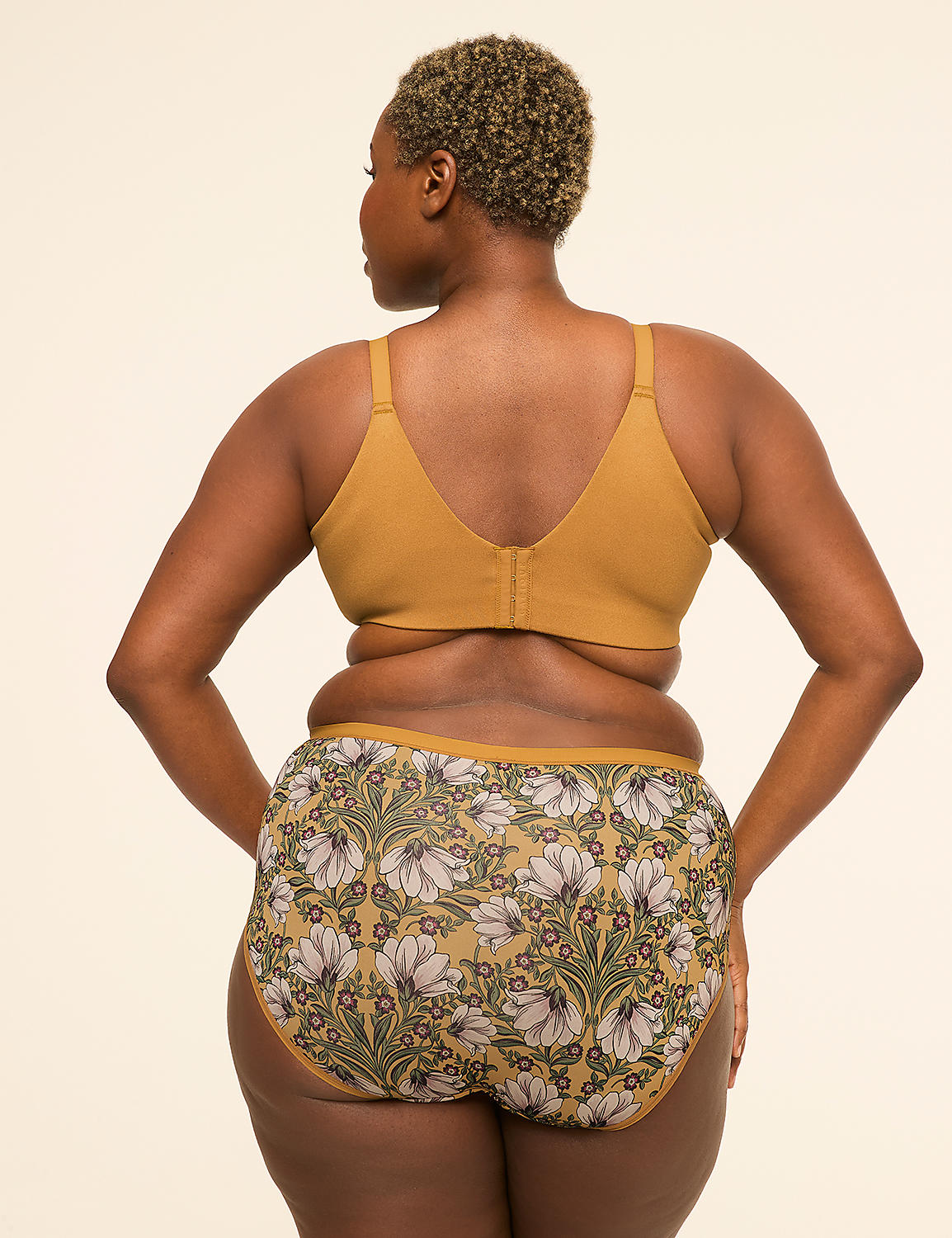 A woman in a mustard-colored bra and floral-patterned underwear stands against a plain, light-colored background. Product Image 2