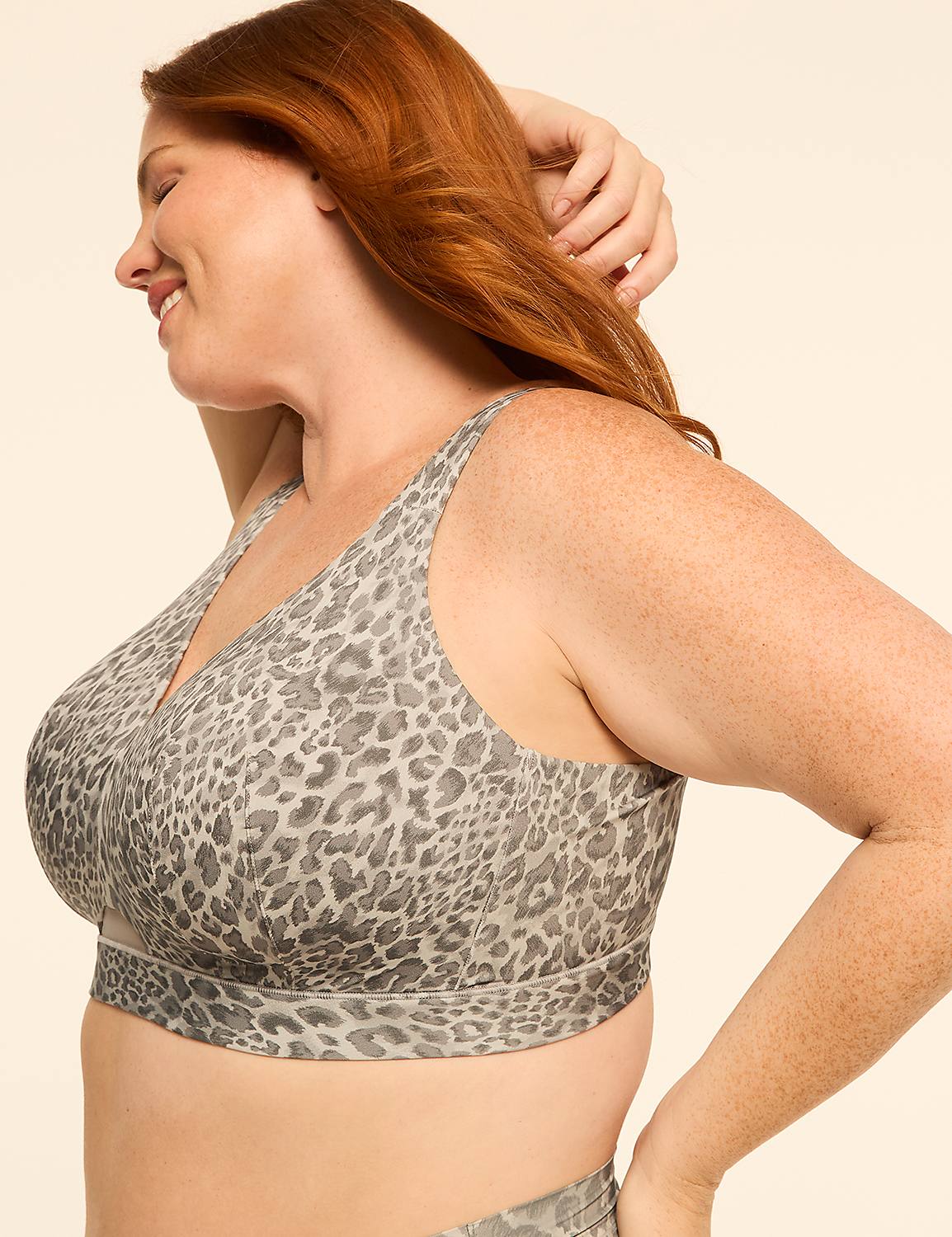 A woman with red hair smiles as she poses in a leopard-print bra against a plain, light-colored background. Product Image 3