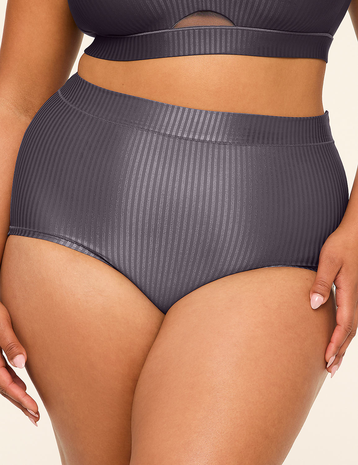 A woman's torso is shown from the waist down, wearing high-waisted, ribbed grey bikini bottoms and a matching bikini top, against a plain, light-colored background. Product Image 1