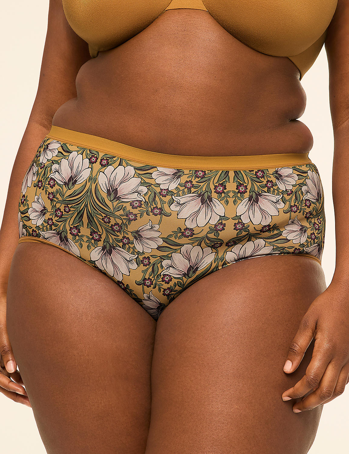 A person wears floral patterned underwear in the foreground against a plain, light-colored background. Product Image 1