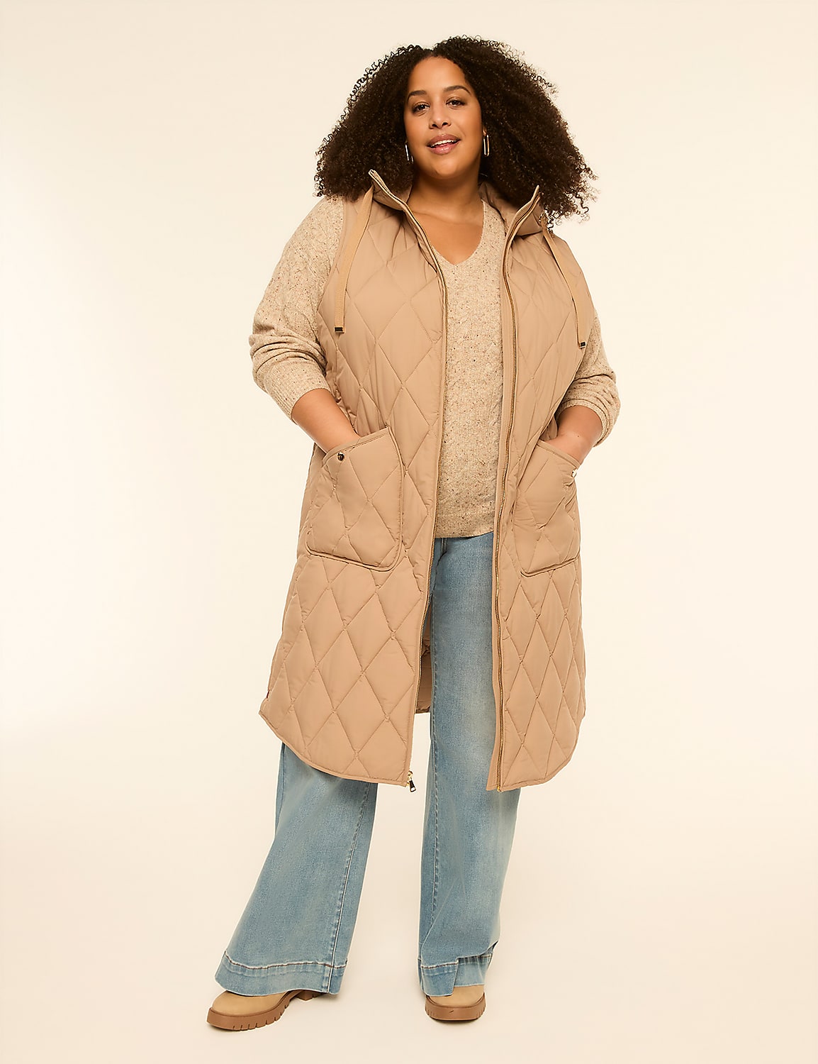 A woman in a quilted vest and wide-leg jeans stands against a plain, light-colored background. Product Image 1