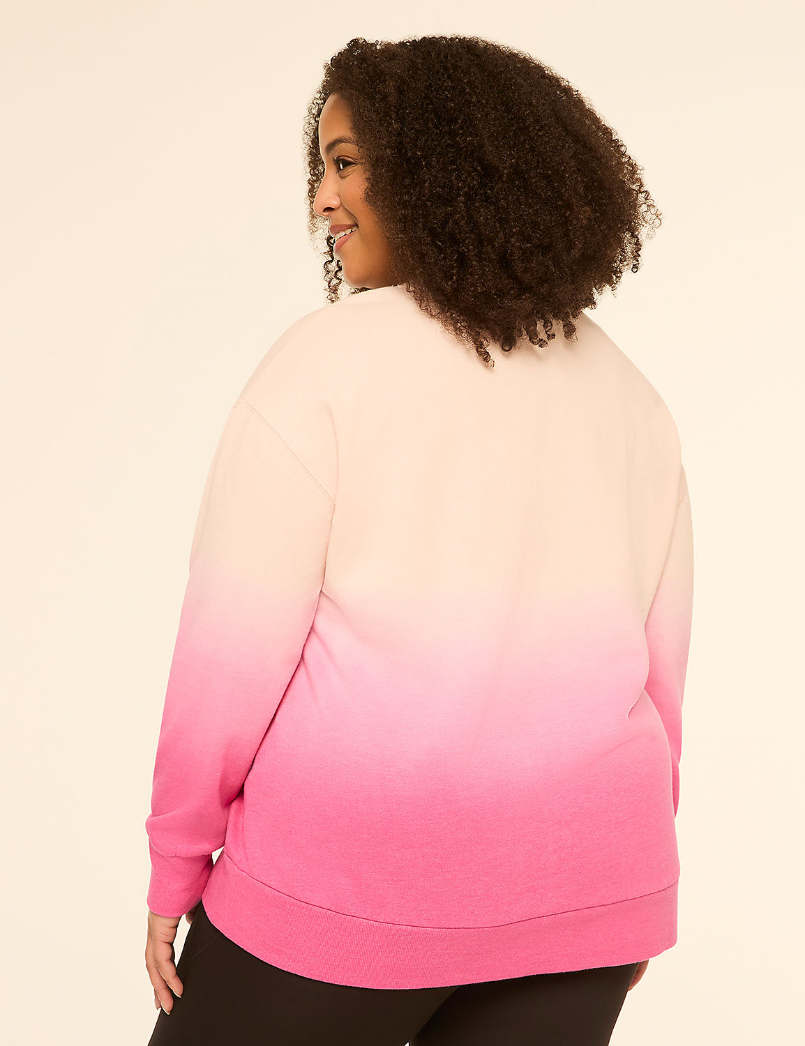 A woman in a pink and cream ombre sweatshirt stands against a plain, light-colored background. Product Image 2