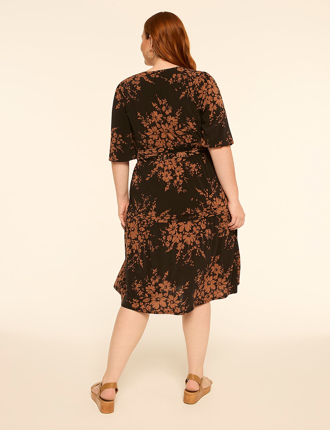 A woman in a floral print dress stands against a plain, light-colored background. Product Image 2
