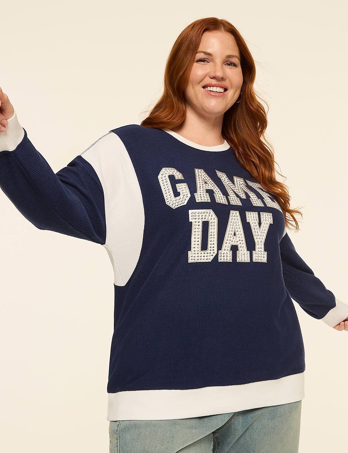 A smiling woman with red hair wears a navy blue and white "GAME DAY" sweatshirt, with a plain, light-colored background. Product Image 1