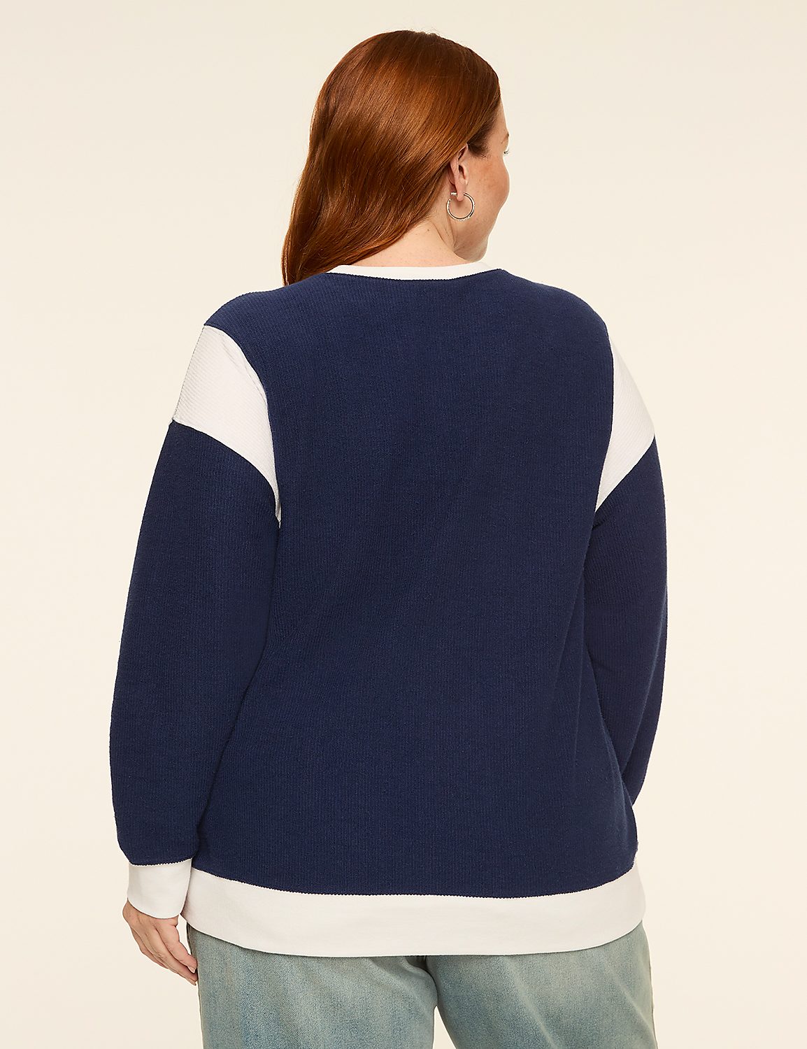 A woman with red hair wearing a navy and white sweatshirt stands against a plain, light-colored background. Product Image 2