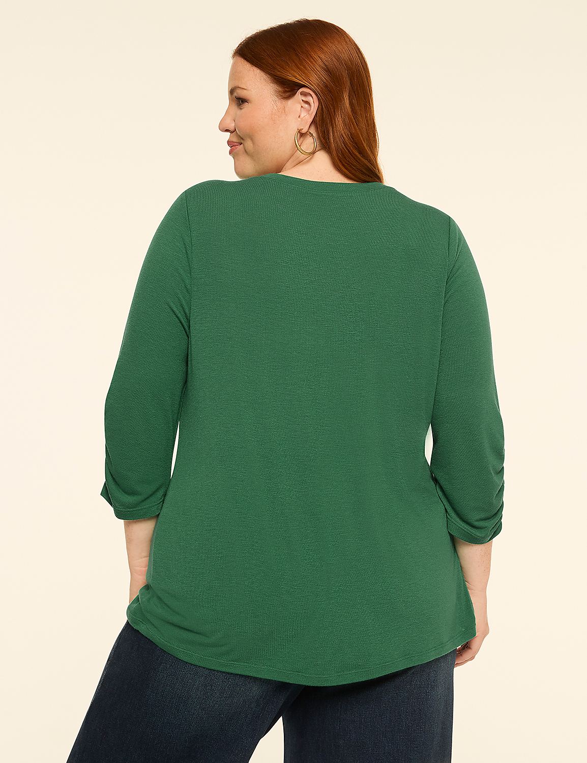 A woman in a green top and blue jeans stands against a plain, light-colored background. Product Image 2