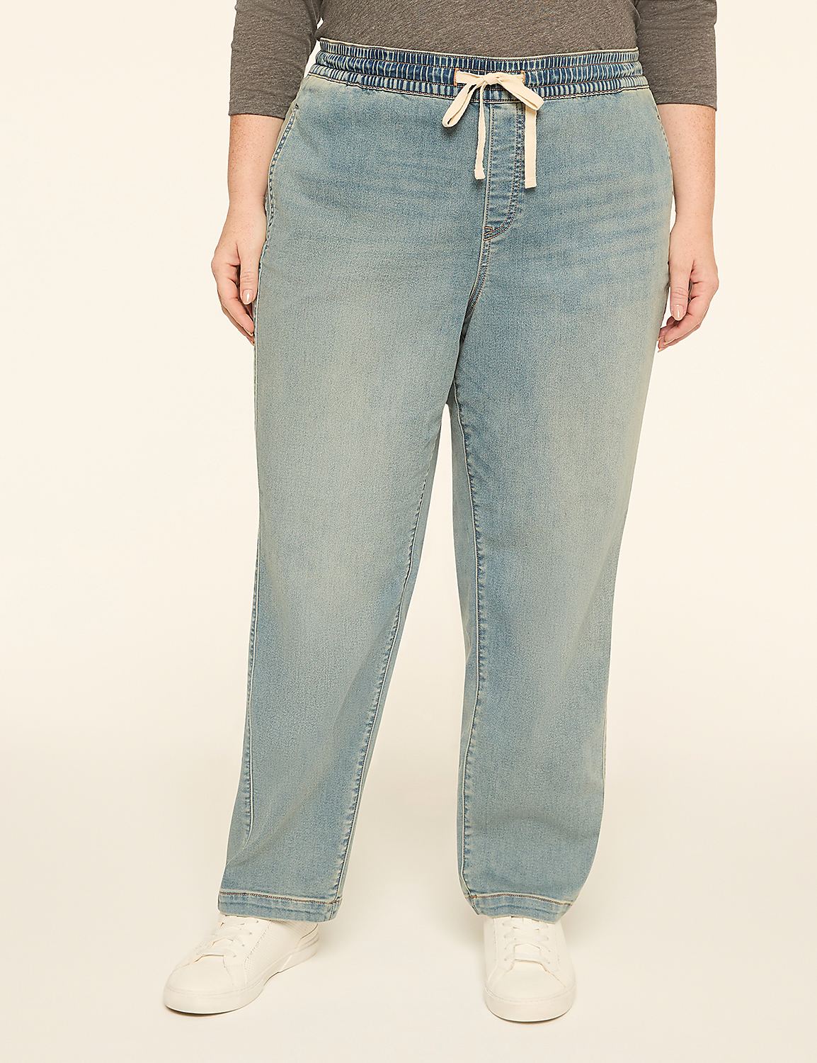 A person wearing light-wash denim pants with a drawstring and white sneakers stands against a plain, light-colored background. Product Image 1