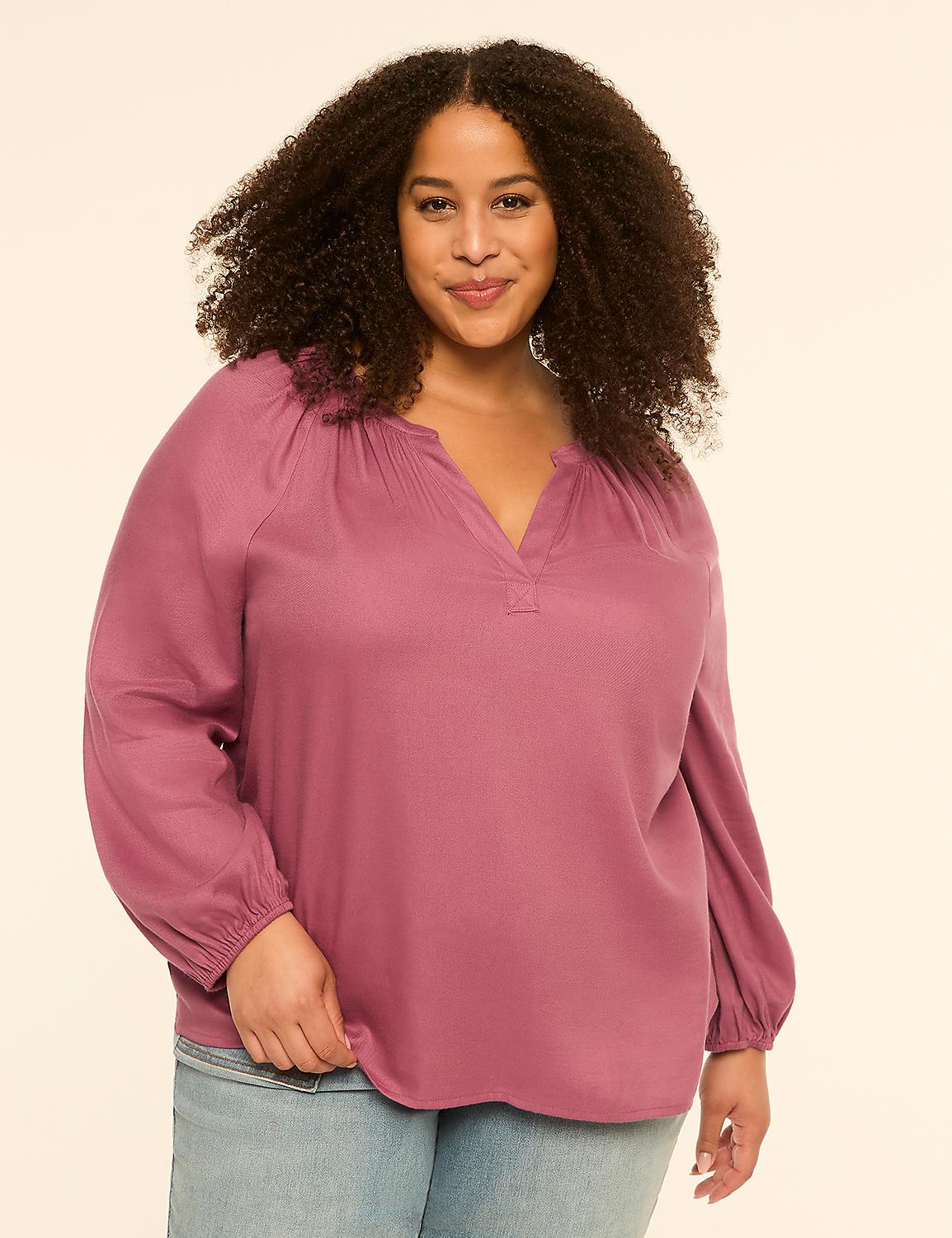 A woman with curly hair smiles at the camera, wearing a mauve blouse and jeans against a plain, light background. Product Image 1