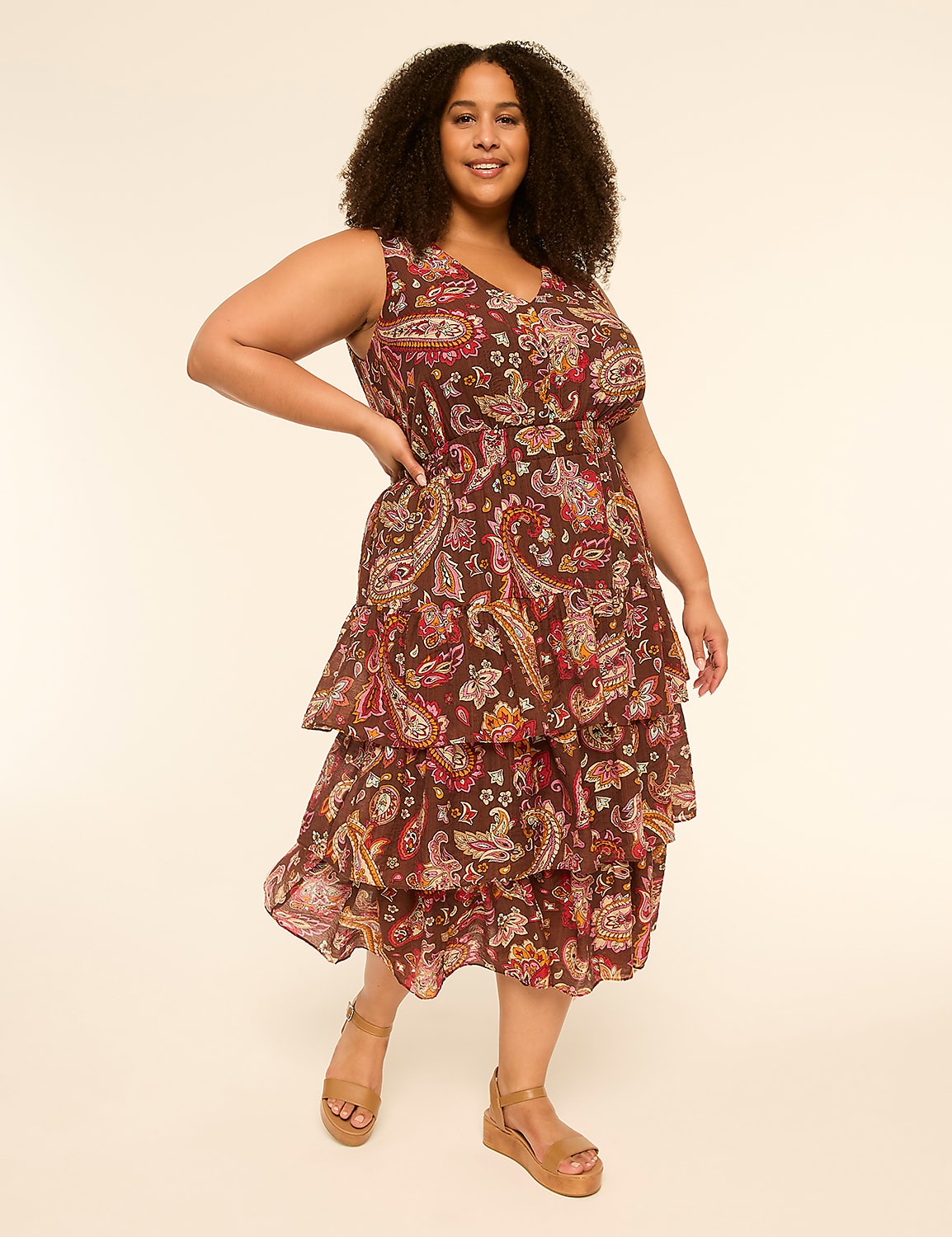 A woman in a tiered paisley dress and wedge sandals stands against a plain, light-colored background. Product Image 1