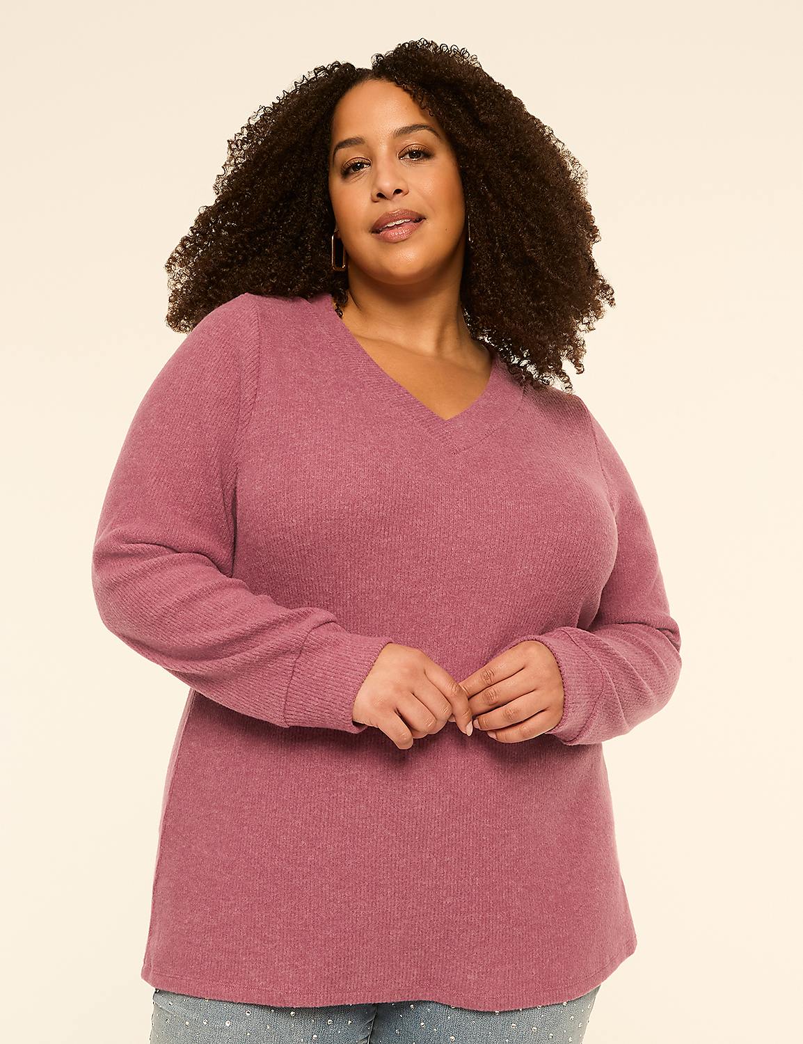 A woman with curly hair and a v-neck sweater stands against a plain, light-colored background. Product Image 1