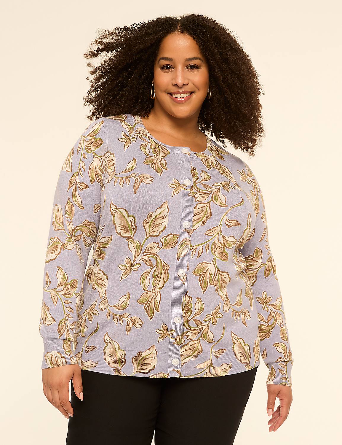 A smiling woman with curly hair wears a floral cardigan over black pants against a plain, light background. Product Image 1