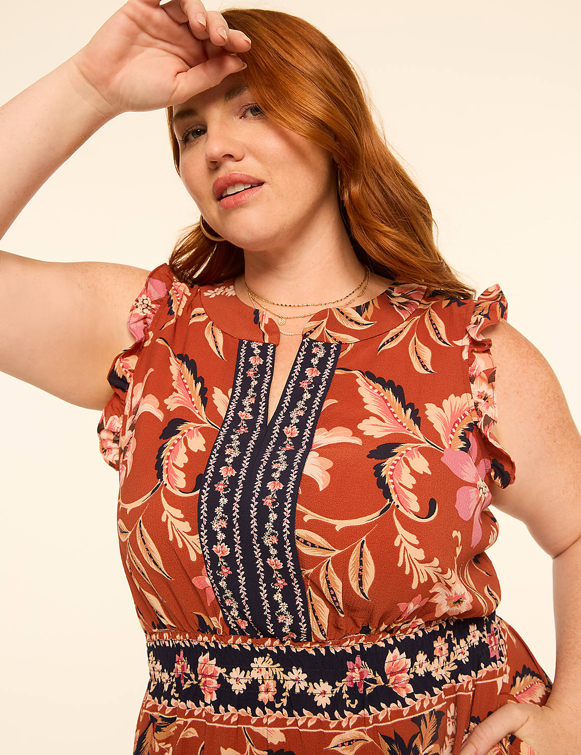 A woman with auburn hair and a floral print dress poses against a plain, light-colored background. Product Image 3