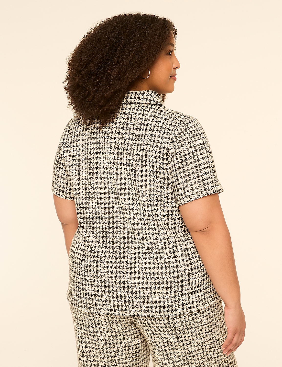 A woman with curly hair, seen from the back, wears a houndstooth patterned shirt and pants against a plain, light-colored background. Product Image 2