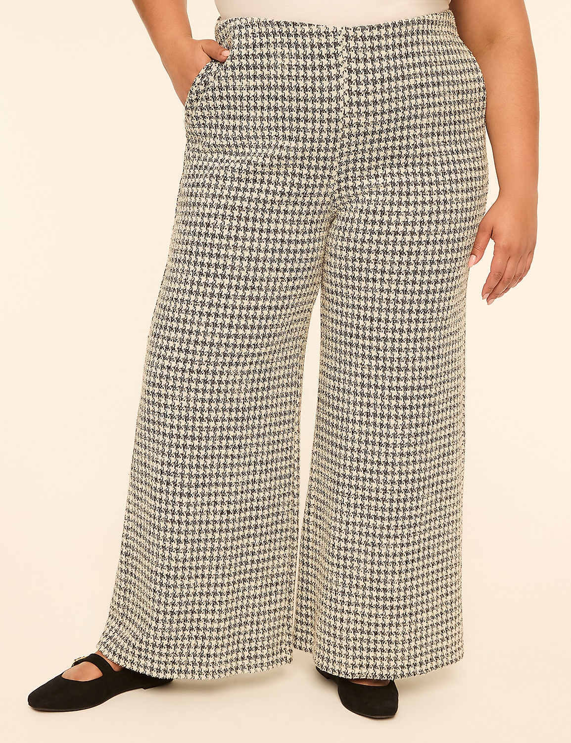 A person wearing wide-leg houndstooth pants stands against a plain, light-colored background. Product Image 1