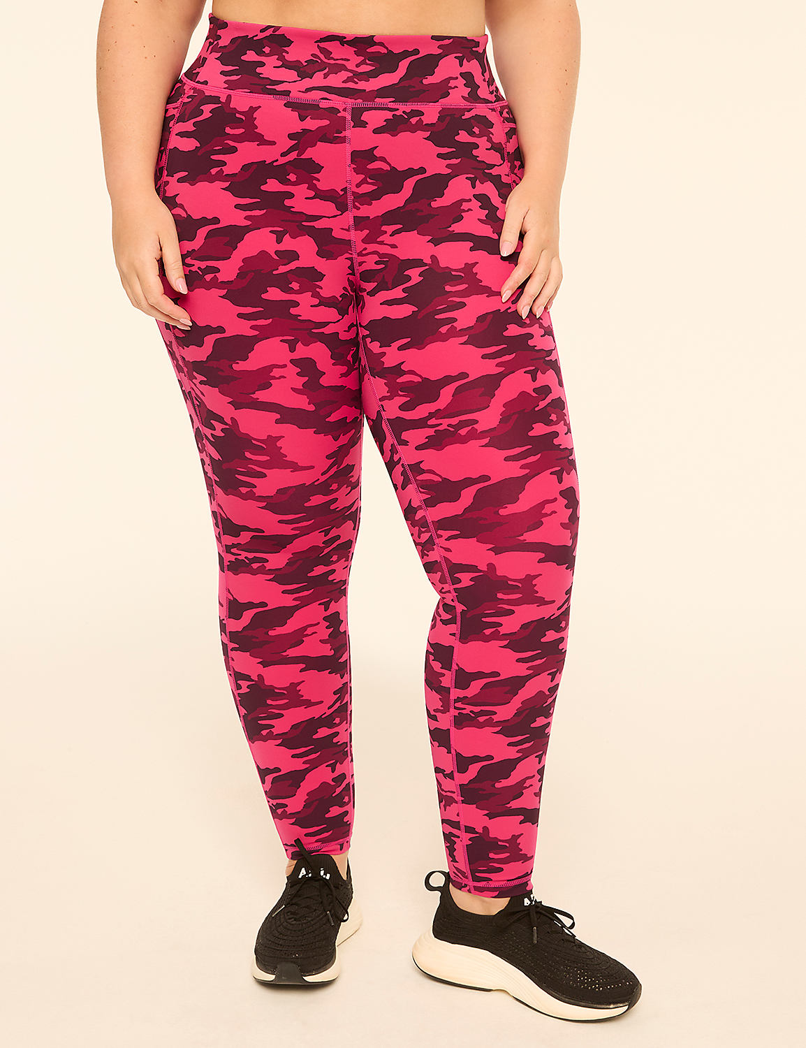 A person wearing pink camouflage leggings and black sneakers stands against a plain, light-colored background. Product Image 1