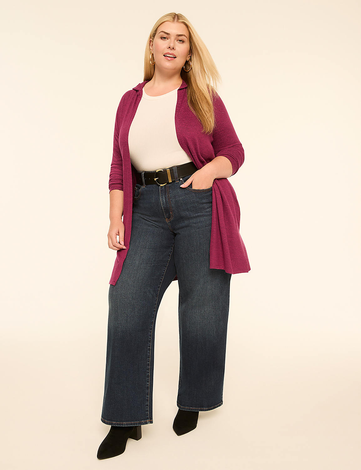 A woman in a white top, dark jeans, and a magenta cardigan stands with her hands in her pockets against a plain, light-colored background. Product Image 3