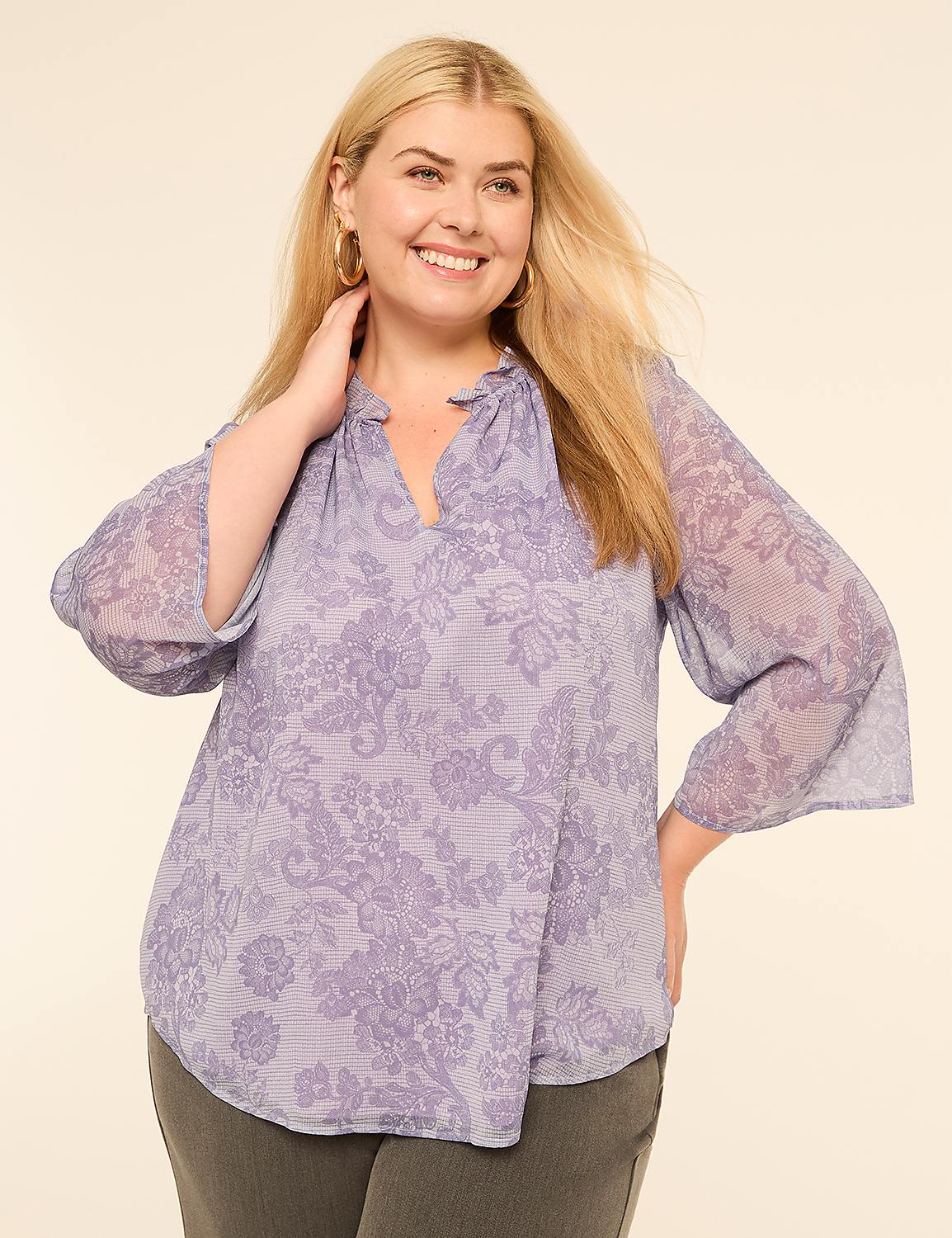 A smiling woman in a floral blouse poses against a plain, light-colored background. Product Image 1