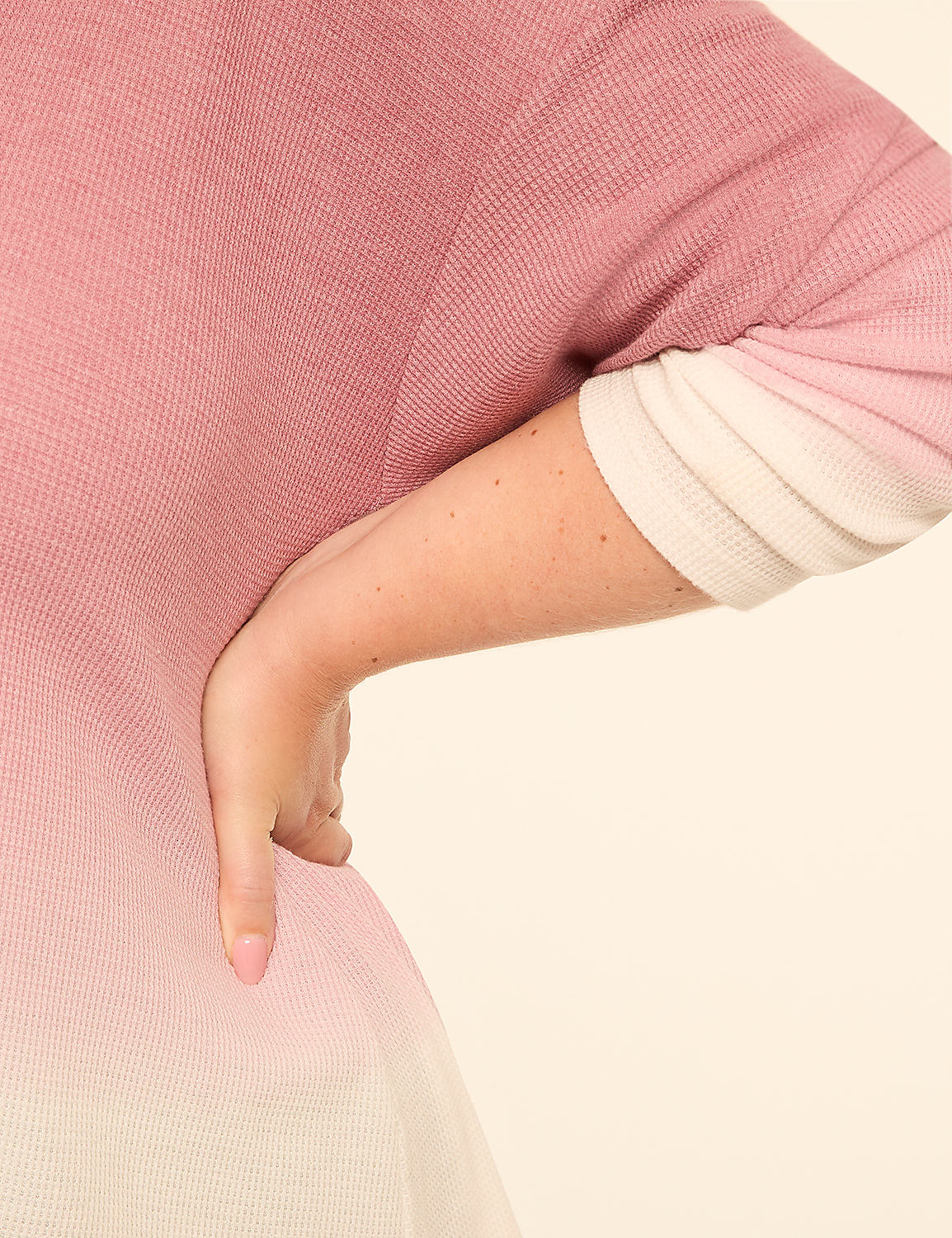 A woman's hand rests on her hip, her arm emerging from a pink and white ombre waffle-knit sweater against a plain cream background. Product Image 4