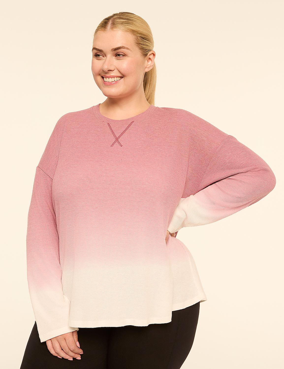 A smiling woman in a pink and white ombre long-sleeved top stands against a plain, light-colored background. Product Image 1