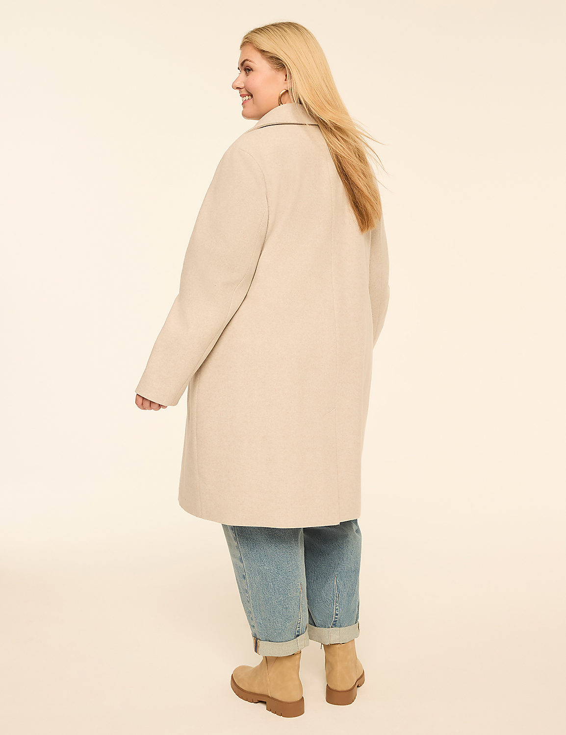 A woman in a cream coat and cuffed jeans stands against a plain, light background. Product Image 2