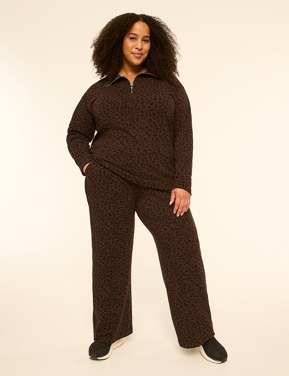 A woman with curly hair stands in the foreground wearing a brown leopard-print loungewear set against a plain, light-colored background. Product Image 3