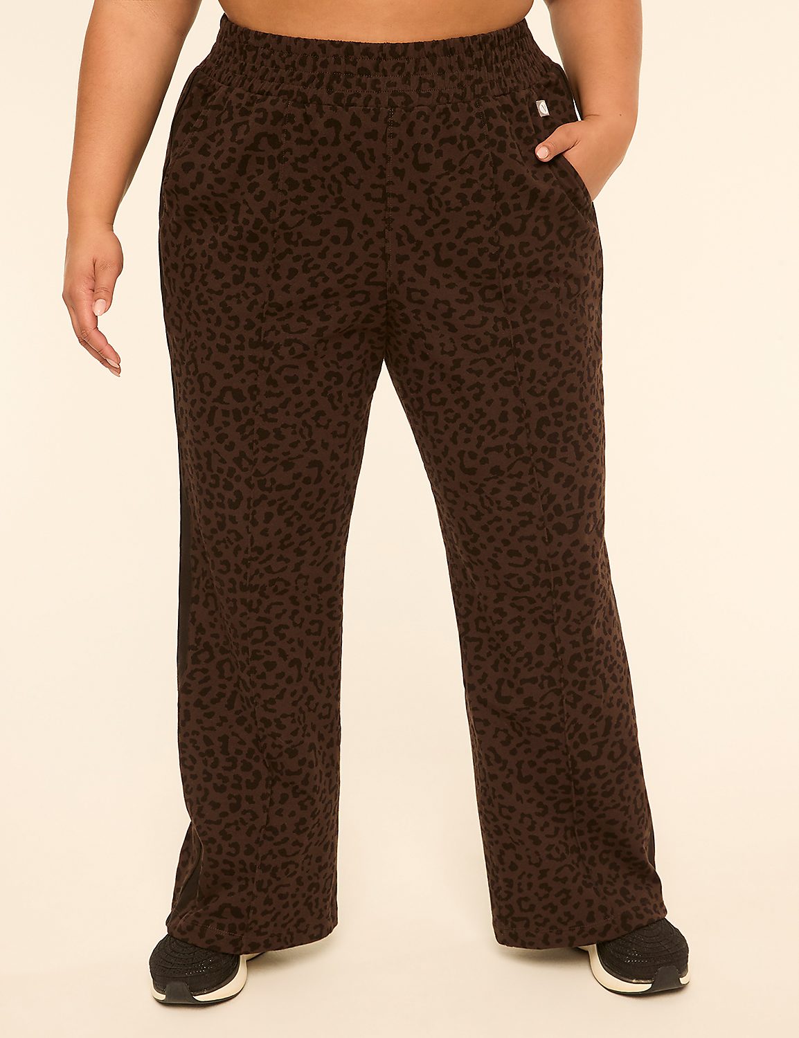 A person wearing brown leopard-print pants stands against a plain, light-colored background. Product Image 1