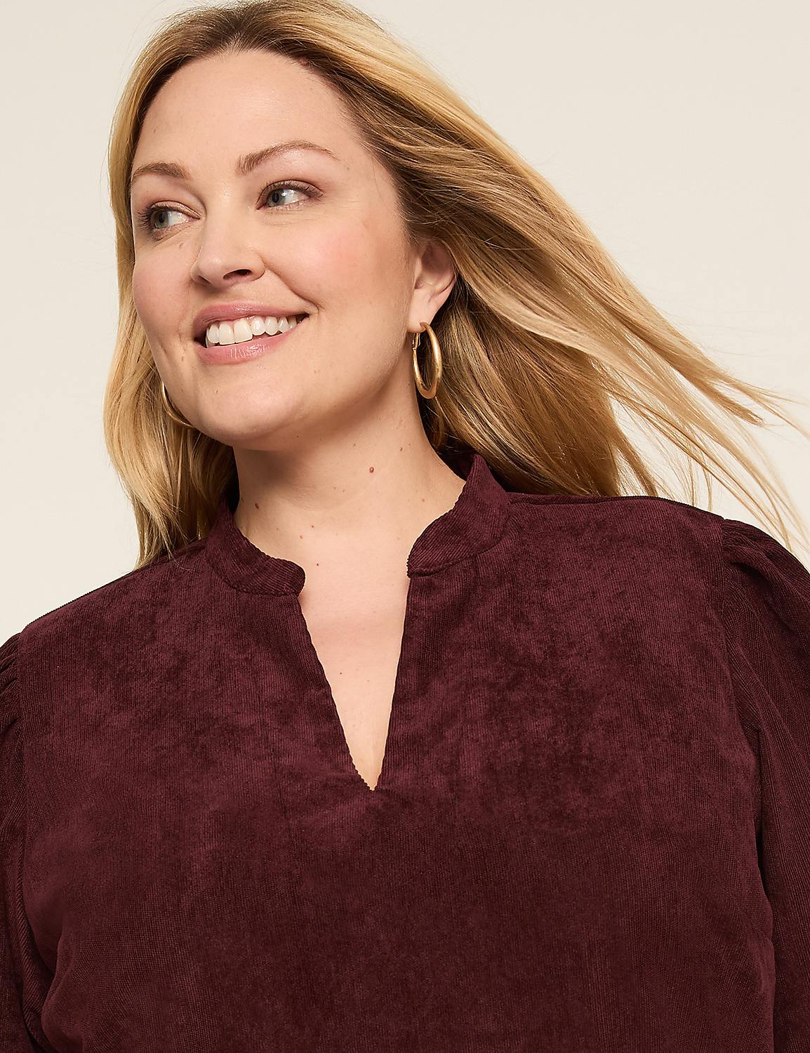 A woman with curly dark hair and a navy blue dress is pictured against a plain, light-colored background. Product Image 3