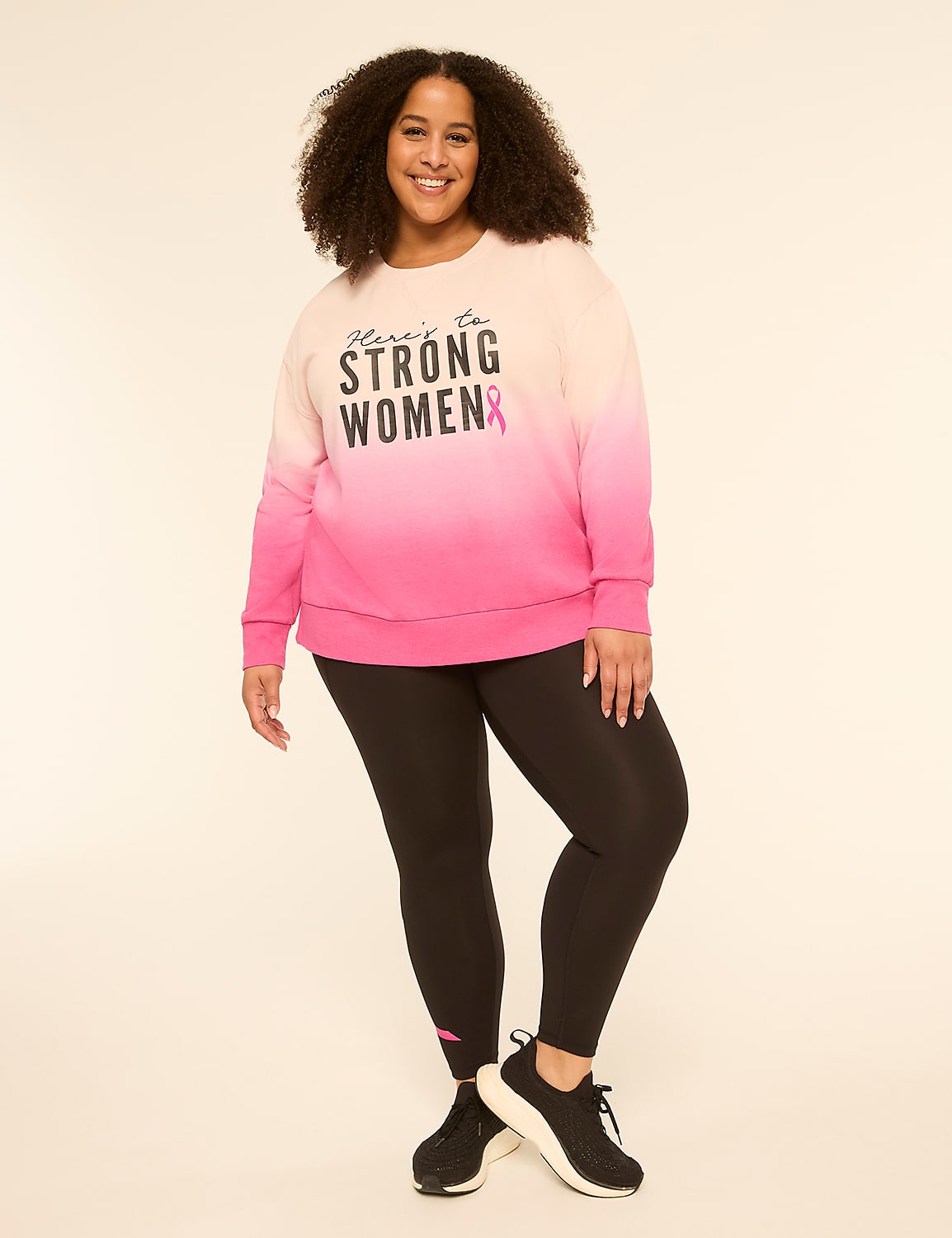 A smiling woman in a pink ombre sweatshirt and black leggings stands against a plain, light background. Product Image 3