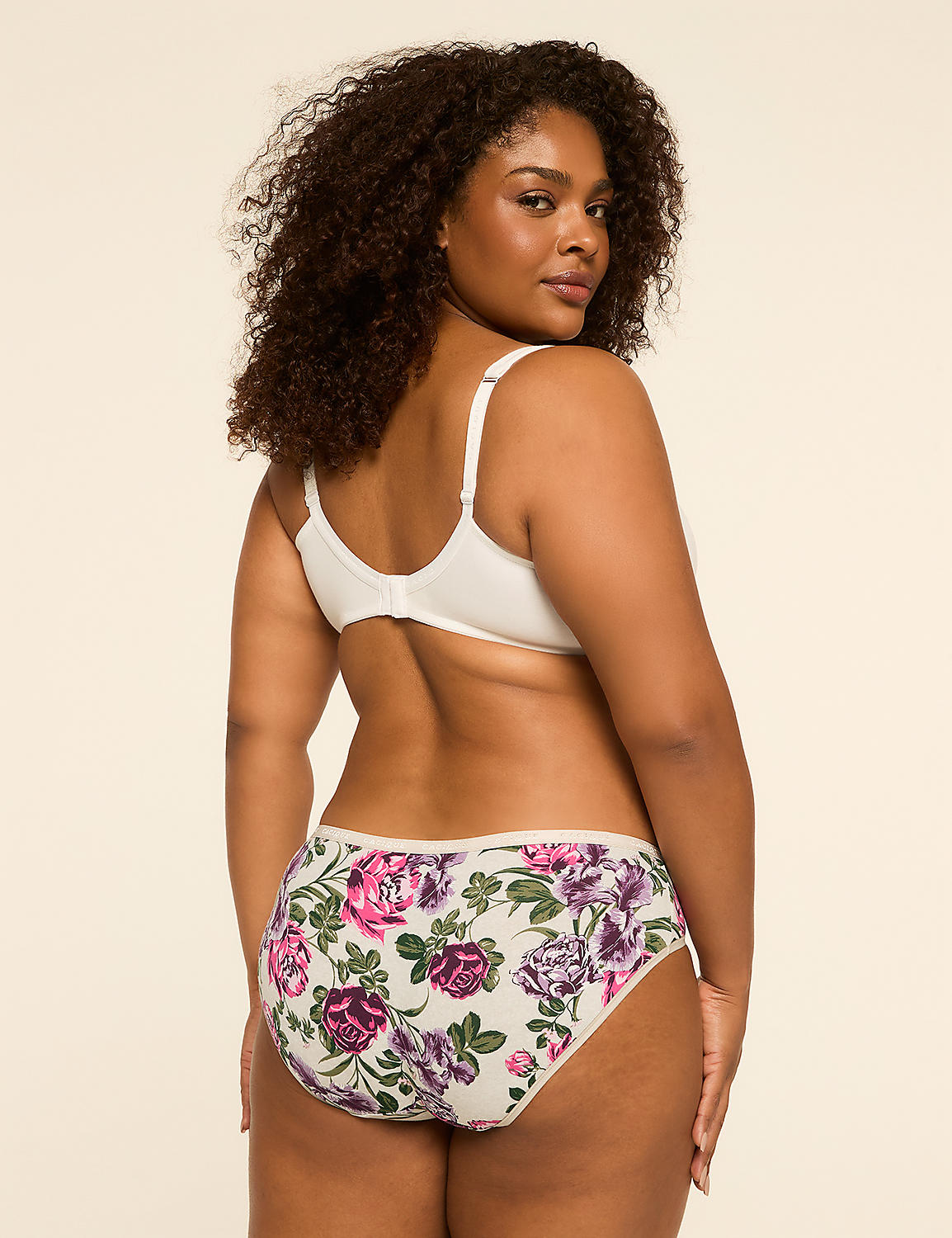 A woman with curly dark hair, wearing a white bra and floral patterned underwear, stands against a plain, light-colored background. Product Image 2