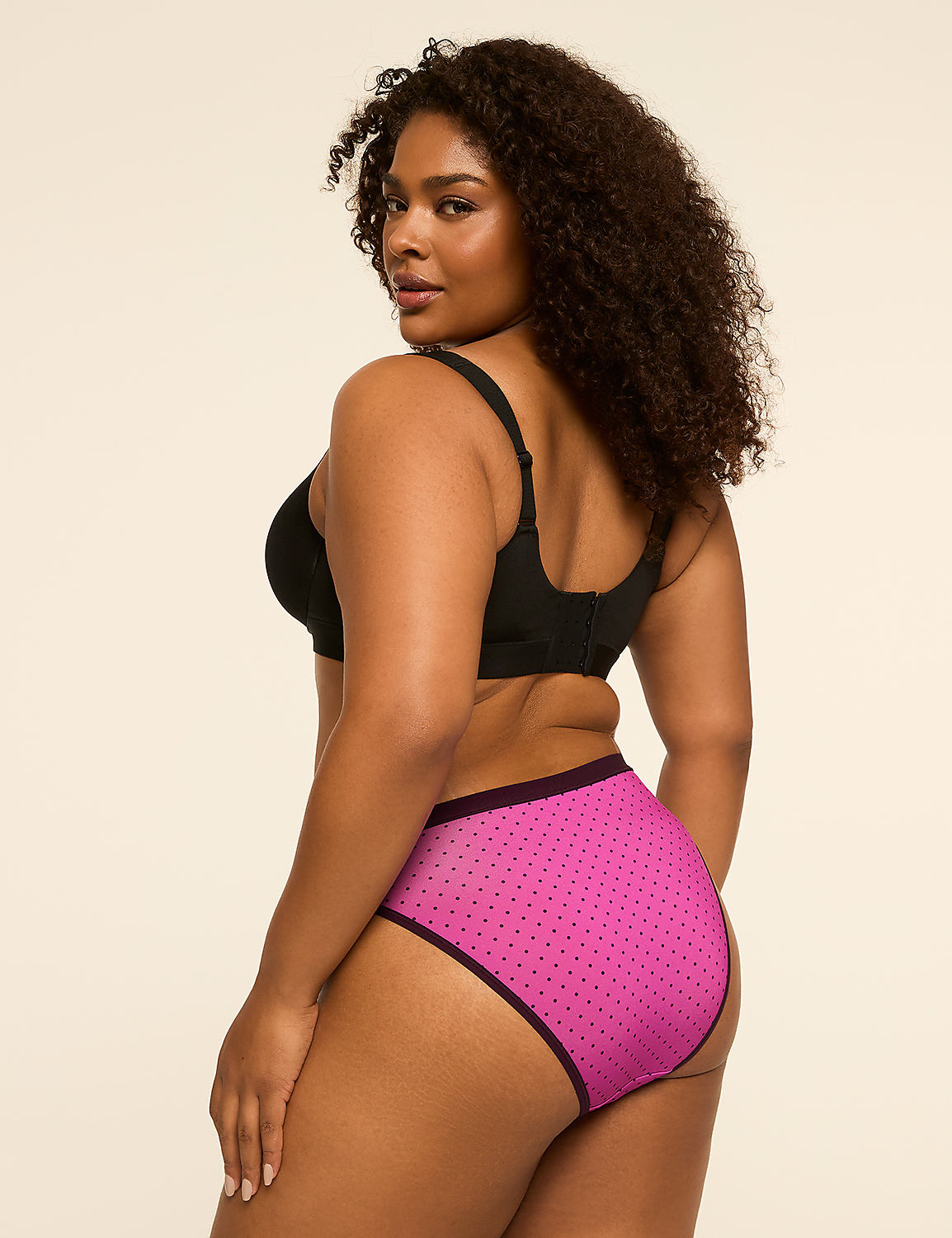 A woman in a black bra and pink polka dot underwear stands against a plain, light-colored background. Product Image 2
