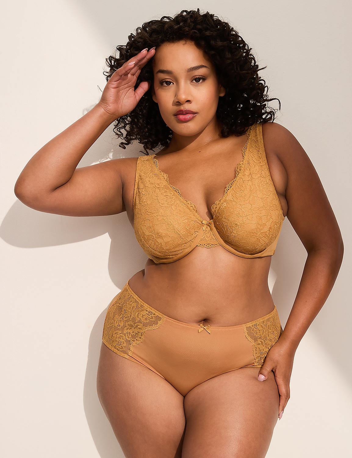 A woman in a mustard-colored lace bra and matching underwear poses against a plain, light-colored wall with soft shadows. Product Image 3