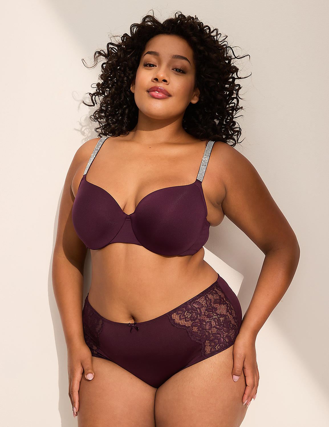 A woman in a plum-colored bra and matching underwear with lace accents stands against a plain, light-colored wall. Product Image 3