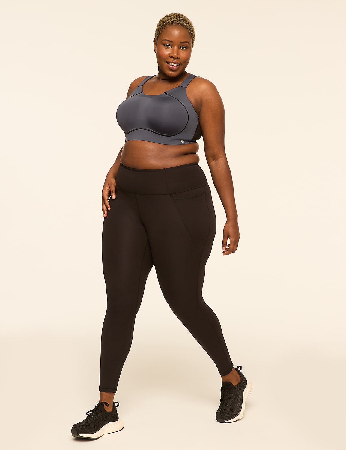 A woman in a grey sports bra and black leggings poses against a plain, light-colored background. Product Image 3