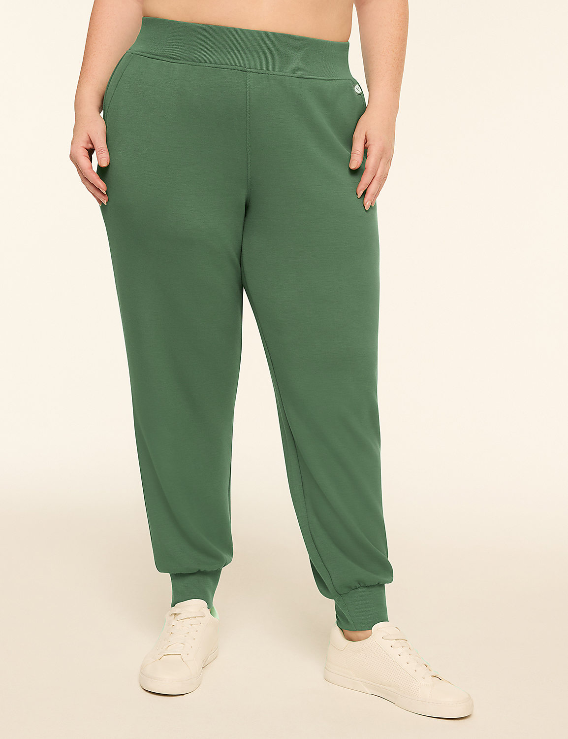 A person wearing green sweatpants and white sneakers stands against a plain, light-colored background. Product Image 1