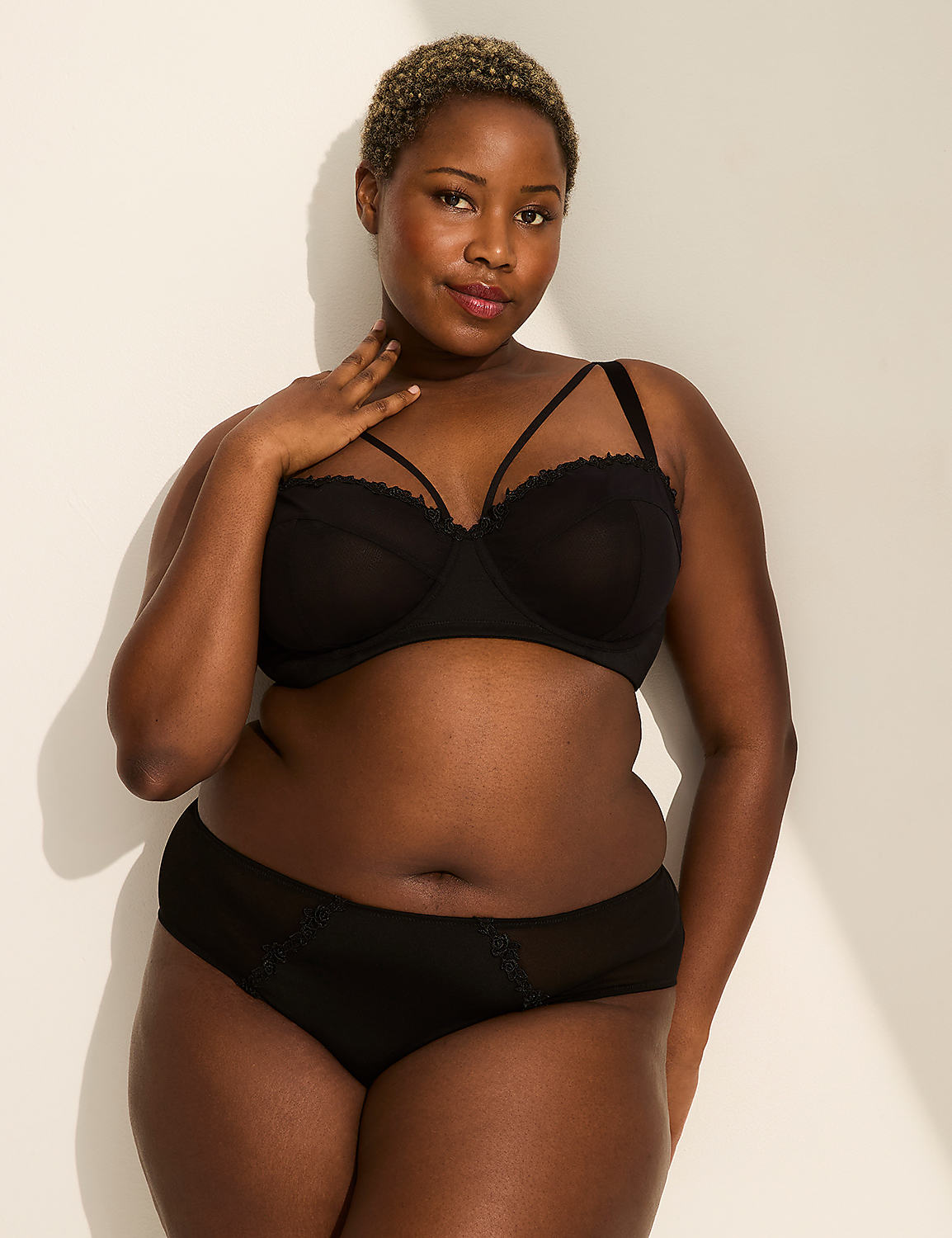 A person's lower body is shown in the foreground, wearing black lingerie, against a plain, light-colored background. Product Image 3