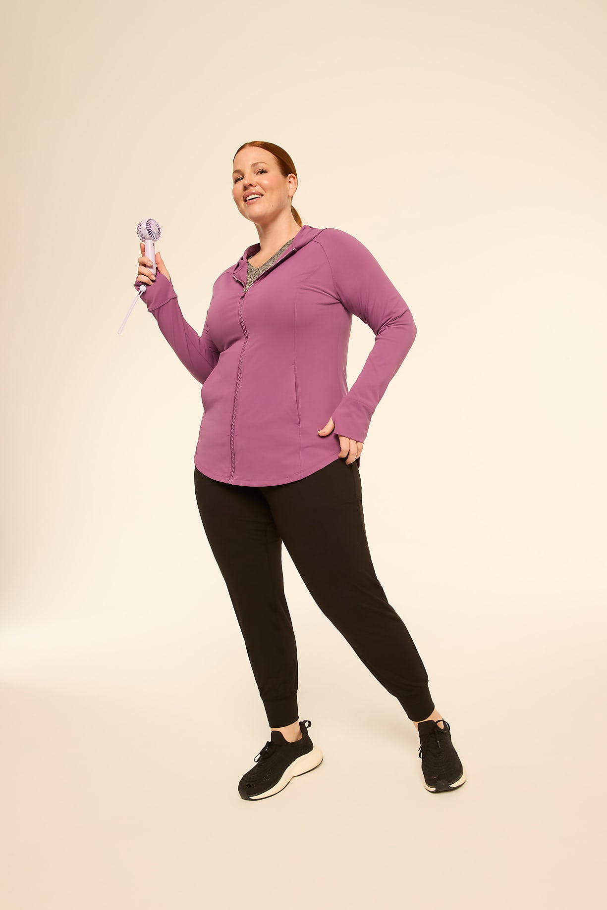 A woman in athletic wear holds a purple jump rope in the foreground against a plain, light-colored background. Product Image 4