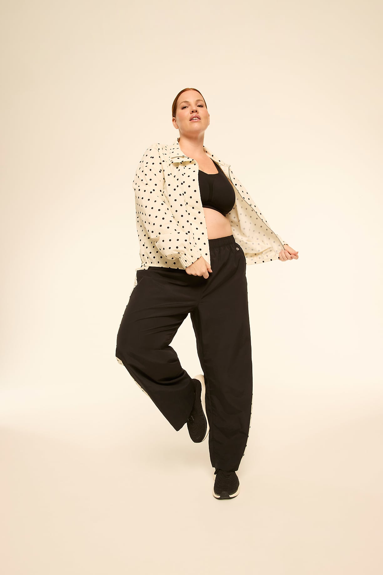 A woman in a polka-dot jacket and black pants poses against a plain, light-colored background. Product Image 5