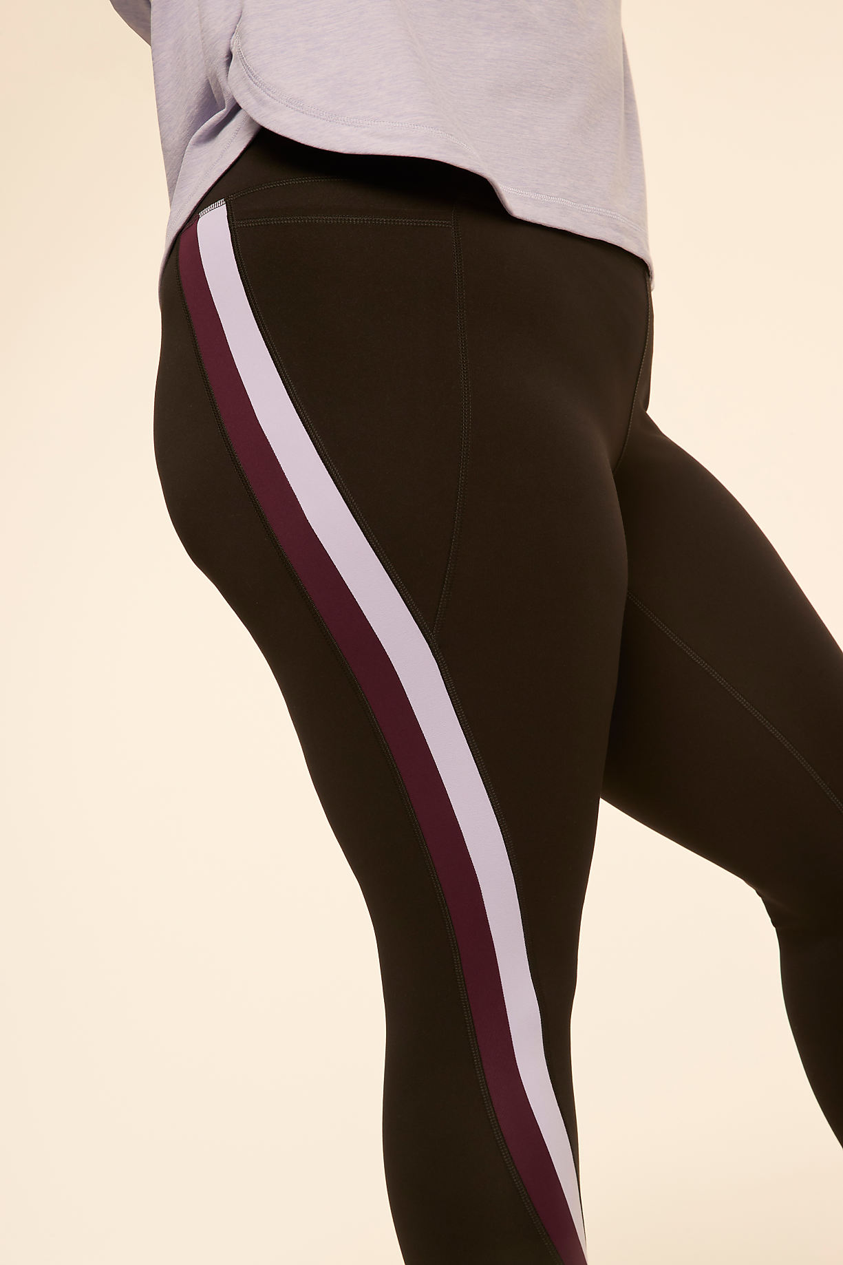 A person in dark leggings with a purple and white stripe stands against a plain, light background. Product Image 5